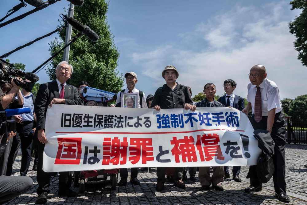 Lawyers and supporters of victims of forced sterilisation under a now-defunct eugenics law, carrying a banner demanding apologies and compensations, march toward the Supreme Court of Japan in Tokyo July 3, 2024. — AFP pic