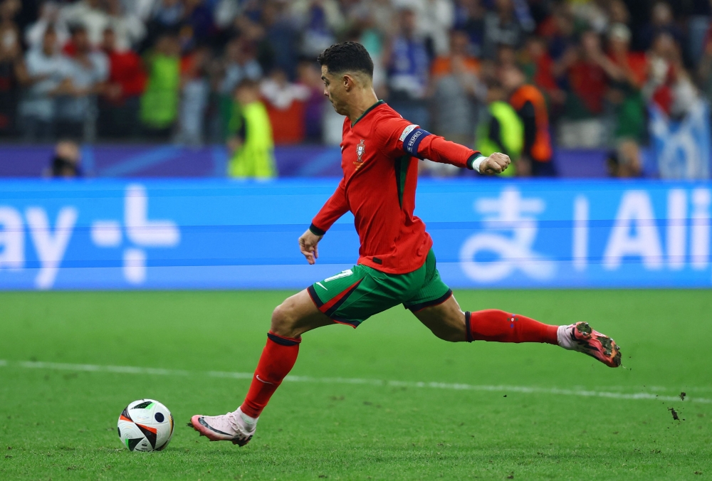 Portugal’s Cristiano Ronaldo scores a penalty during the shoot-out in the match against Slovenia. — Reuters pic