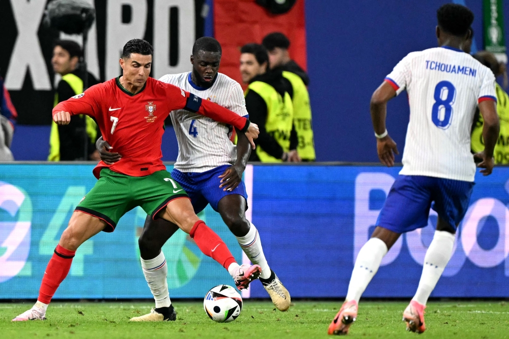 Portugal’s forward #07 Cristiano Ronaldo and France’s defender #04 Dayot Upamecano fight for the ball. — AFP pic