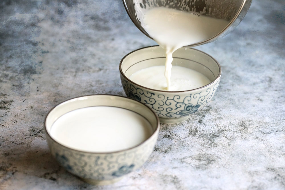 Pour the hot milk into the bowl of ginger juice.