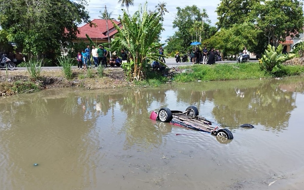 A family of three narrowly escaped drowning after their Proton Pesona plunged into a river along Jalan Kangar-Alor Setar, Kampung Tok Pulau in Perlis July 7, 2024. — Picture courtesy of Perlis Fire and Rescue Department 