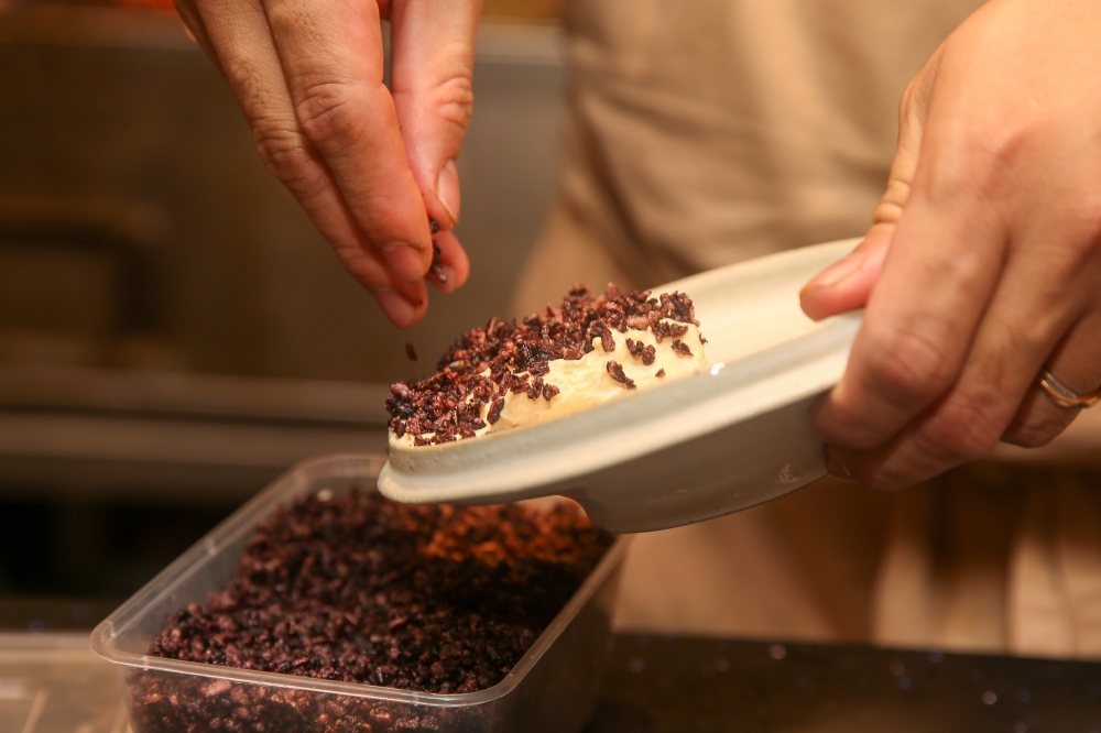 Lau putting the finishing touches to the ‘pulut hitam’ ice cream dessert.