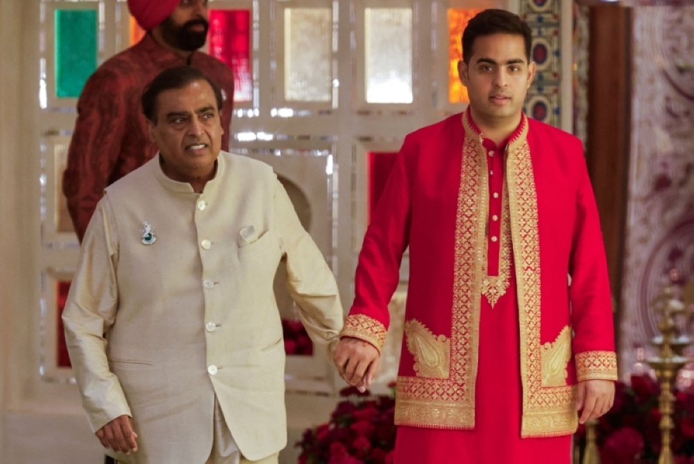 Indian businessman Mukesh Ambani with his son Akash during the haldi ritual of his son Anant before his wedding, at his residence in Mumbai, India on July 8. — Reuters pic