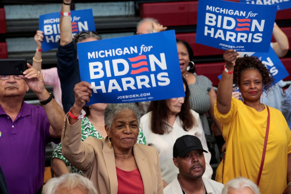 People hold placards in support of US President Joe Biden during a campaign stop in Detroit, Michigan July 12, 2024. — Reuters pic  