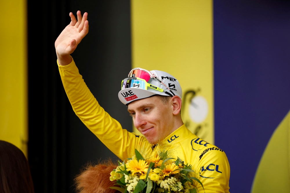 UAE Team Emirates' Tadej Pogacar celebrates on the podium wearing the yellow jersey after Tour de France stage 13 from Agen to Pau July 12, 2024. — Reuters pic  