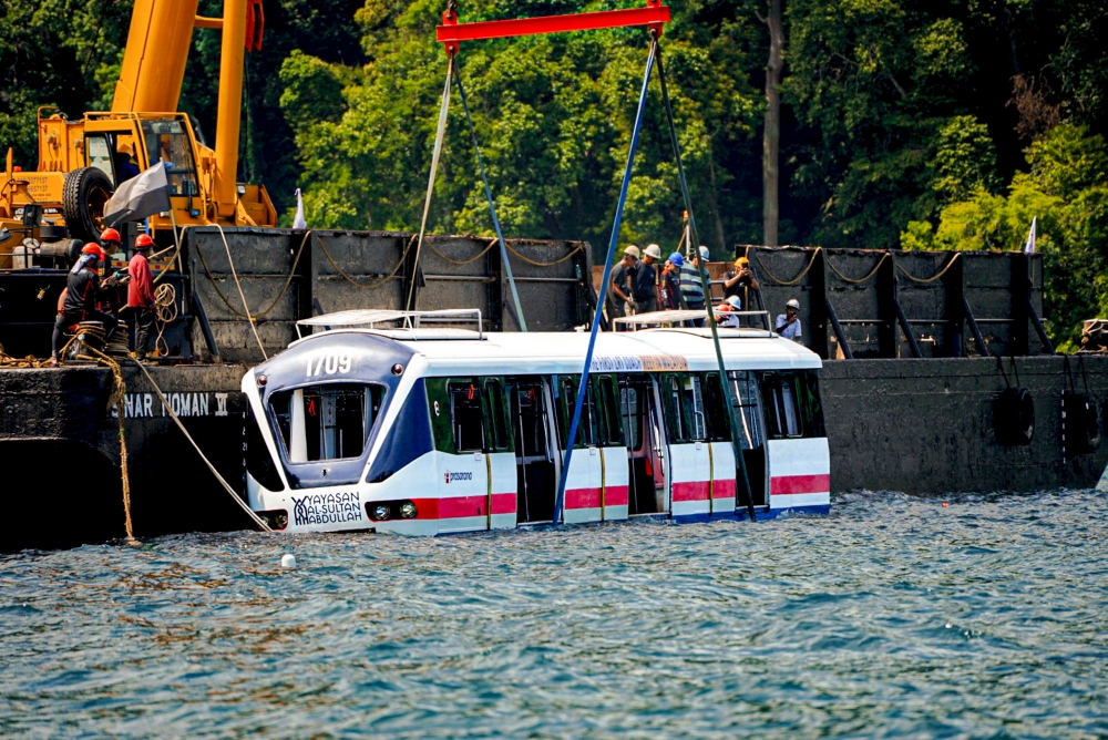 The two LRT carriages are seen in the process of being submerged. — Bernama pic