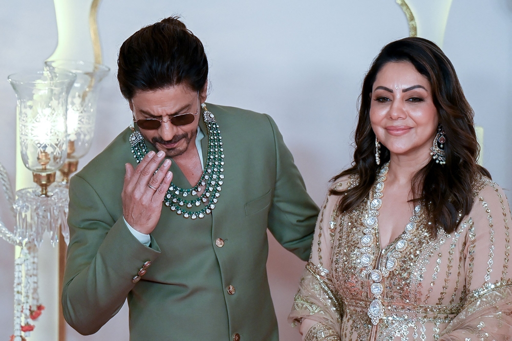 Bollywood actor Shah Rukh Khan with his wife Gauri Khan pose for photos. — AFP pic 