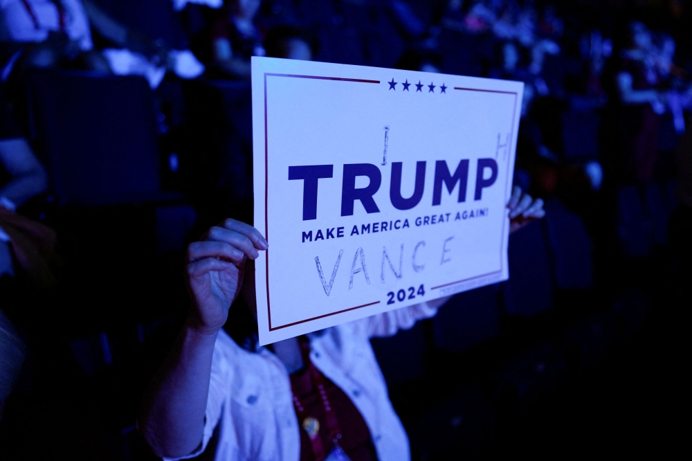 An attendee holds a makeshift sign supporting Republican presidential nominee and former US President Donald Trump and Republican vice presidential nominee JD Vance on Day 1 of the Republican National Convention (RNC) at the Fiserv Forum in Milwaukee, Wisconsin July 15, 2024. — Reuters pic  