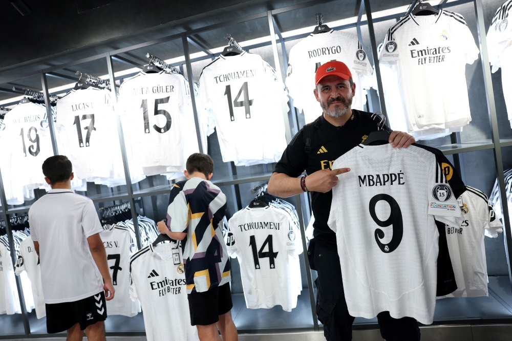 Real Madrid fans shop for Kylian Mbappe's new shirt in the official shop ahead of his presentation at Santiago Bernabeu stadium next week in Madrid July 12, 2024. — Reuters pic  