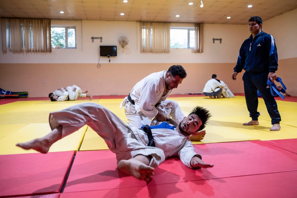 In this photograph taken on June 27, 2024, Afghan judo fighter Mohammad Samim Faizad (top) takes part in a training session with fellow judoka Shamsuddin Payenda Zadah at the Afghanistan Judo Federation in Kabul, ahead of Faizad’s participation in the Paris 2024 Olympic Games. — AFP pic 