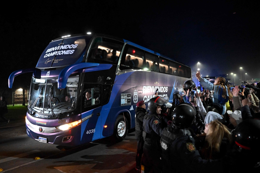 Fans take pictures of a bus transporting the Argentina's national football team in Ezeiza, Buenos Aires, Argentina on July 15, 2024. — AFP pic