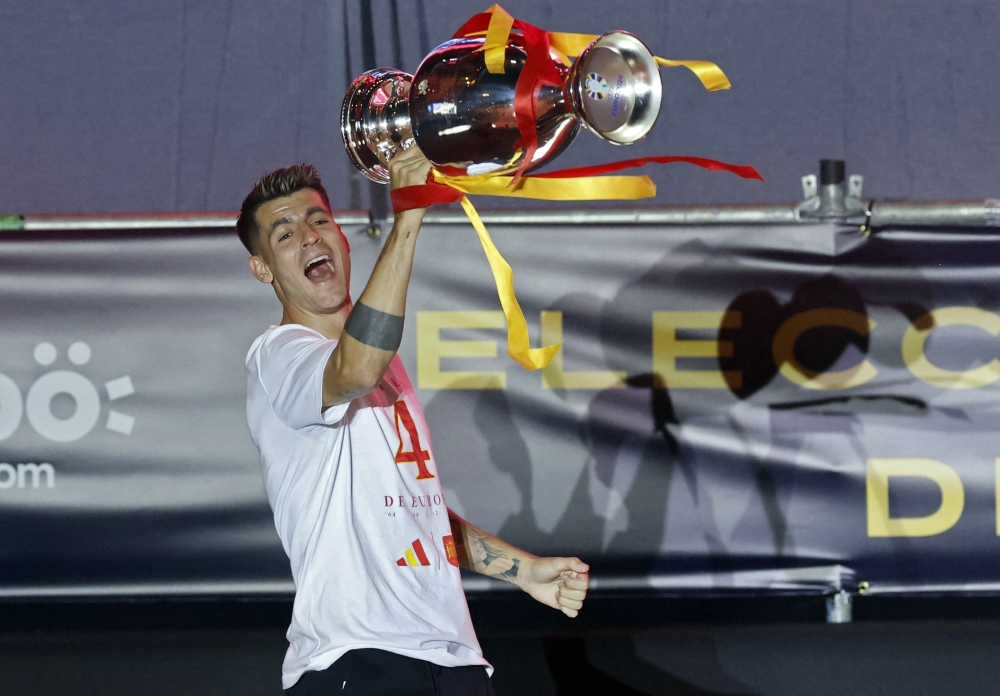 Spain's forward Alvaro Morata celebrates with the trophee as Spanish national football team players celebrate on the stage at Cibeles Square, with Spain fans, on July 15, 2024. — AFP pic