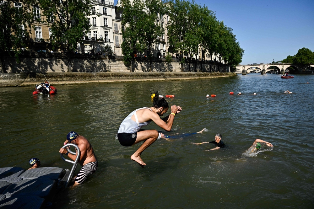 Local residents swimming in the Seine after Paris Mayor Anne Hidalgo took a dip in the murky waters on July 17. — AFP pic