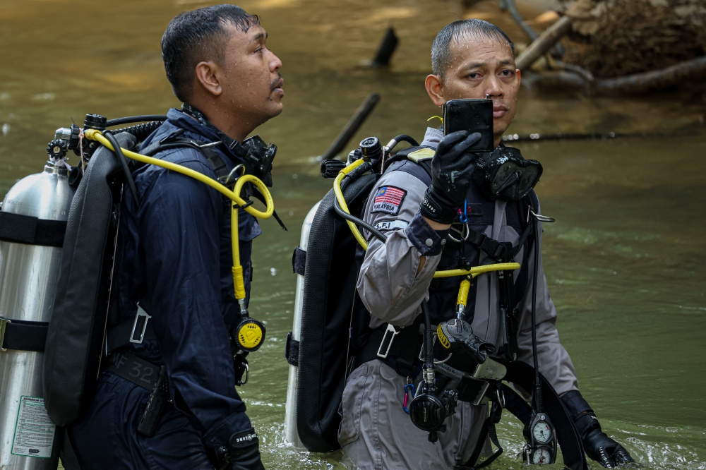 A diving team from the police’s Underwater Forensic Investigation Unit found a wallet believed to be linked to the murder of Nur Farah Kartini Abdullah while searching for evidence in the Trolak River, Kampung Batu 4, Trolak, July 22, 2024. — Bernama pic 