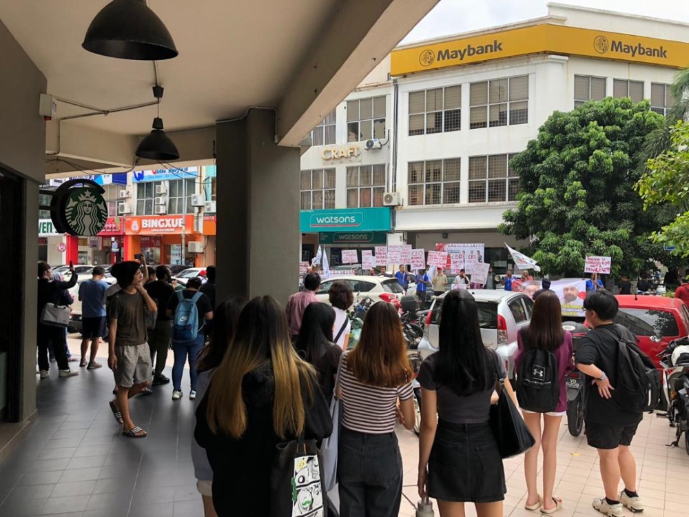 Members of the public observe the picket in progress at a Maybank branch in Cheras today. — Picture courtesy of Nube