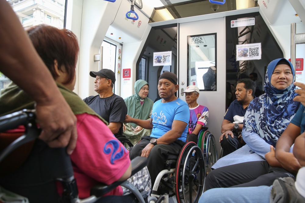 People with disabilities ride on a trackless tram outside the Putrajaya Sentral Station in Putrajaya, on July 21, 2024. — Picture by Yusof Mat Isa