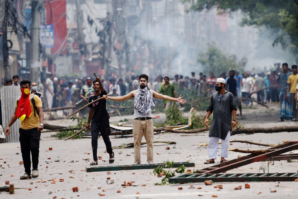 A demonstrator gestures as protesters clash with Border Guard Bangladesh (BGB) and the police outside the state-owned Bangladesh Television in Dhaka on July 19 — Reuters pic