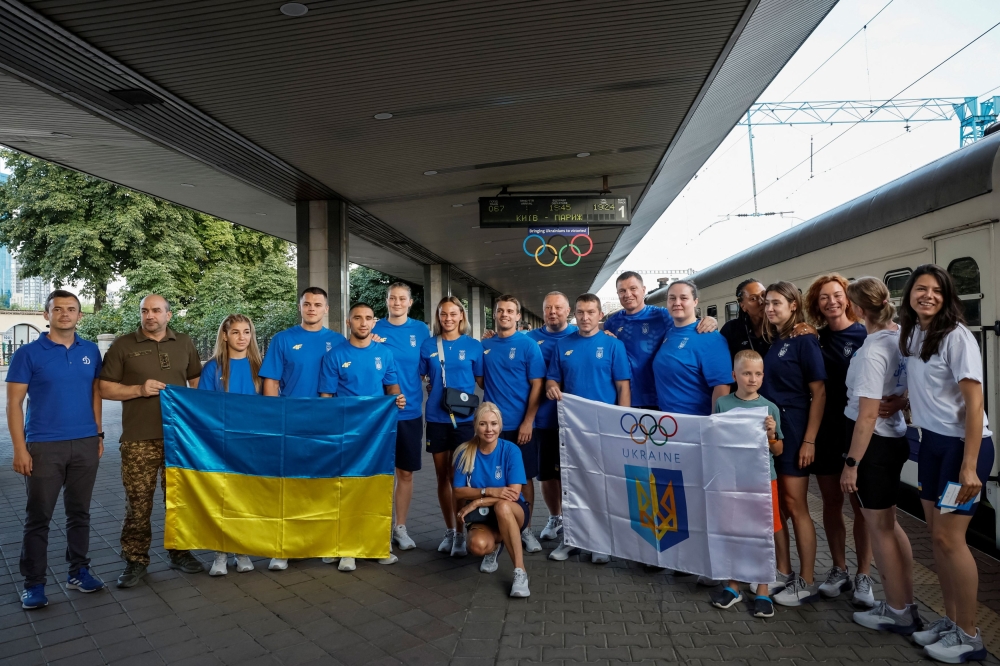 Members of the Ukrainian Olympic judo and fencing teams pose for a picture with a Ukrainian national flag before boarding a train to the Paris 2024 Olympics via Poland, amid Russia's attack on Ukraine. — Reuters pic