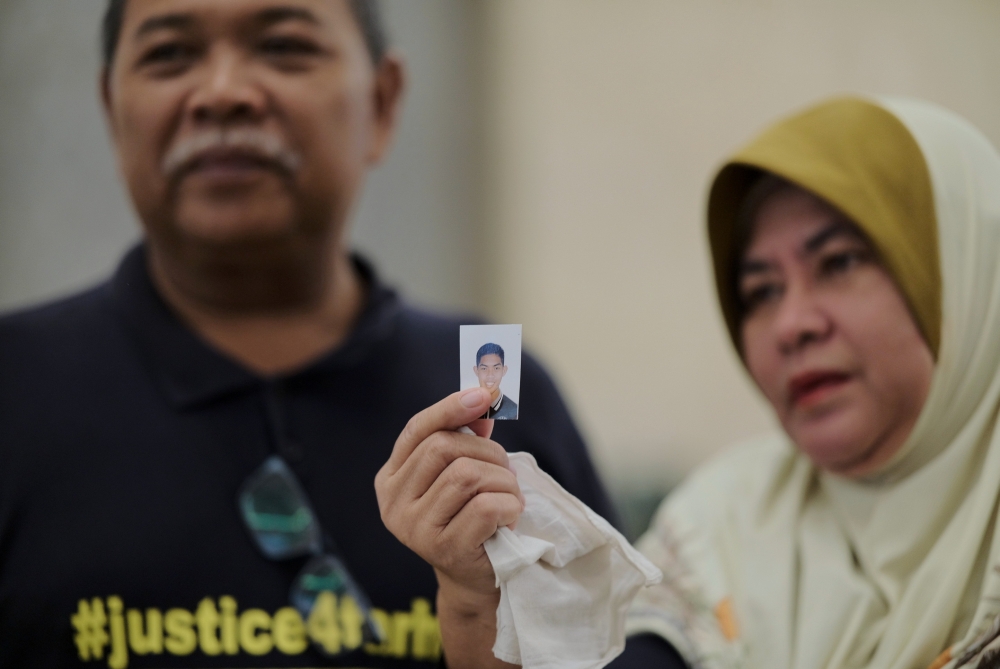 Zulkarnain Idros (left), father of murdered former Universiti Pertahanan Nasional Malaysia (UPNM) student Zulfarhan Osman Zulkarnain, and his wife Hawa Osman, hold a photo of their late son after the Court of Appeal sentenced six former UPNM students to death at the Palace of Justice in Putrajaya July 23, 2024. — Bernama pic