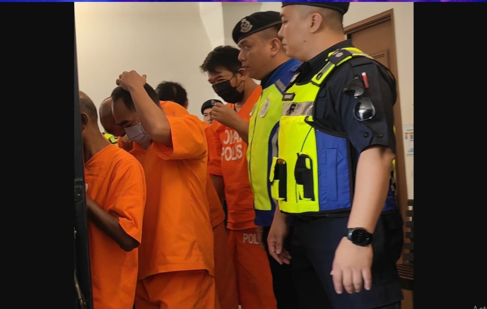 Policemen escort the male accused following proceedings at the Kota Kinabalu Court Complex. — The Borneo Post pic 