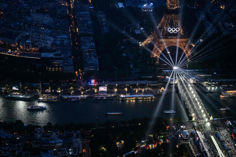 A photograph taken from an helicopter on July 26, 2024 shows an aerial view of delegation boats navigating down the Seine river near the illuminated Eiffel Tower during the opening ceremony of the Paris 2024 Olympic Games in Paris. — AFP pic 