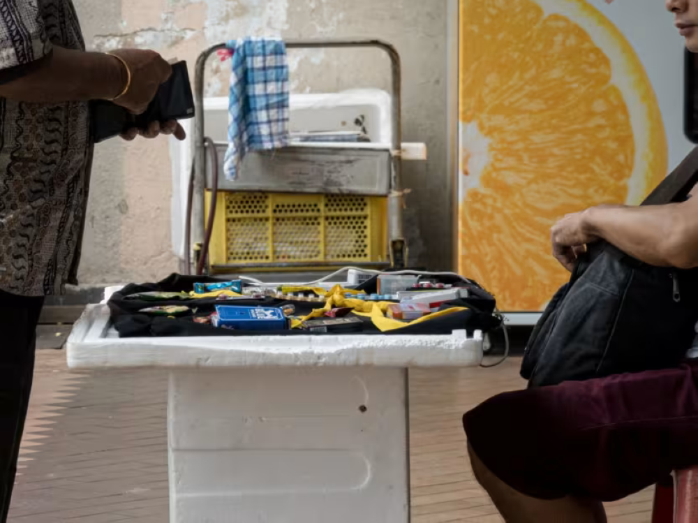 An illegal street peddler sells pills on a sidewalk along Geylang Road on July 19, 2024. It is not uncommon to find peddlers selling illegal sex enhancement drugs of various shapes, sizes and colours that may look like harmless candy to the uninitiated. — Nuria Ling/TODAY