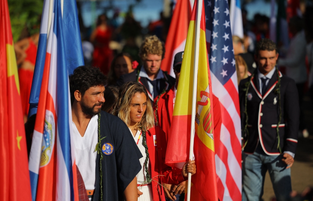 Athletes participate in a flag parade on the day of Paris 2024 Olympics opening ceremony in Tahiti. — Reuters pic