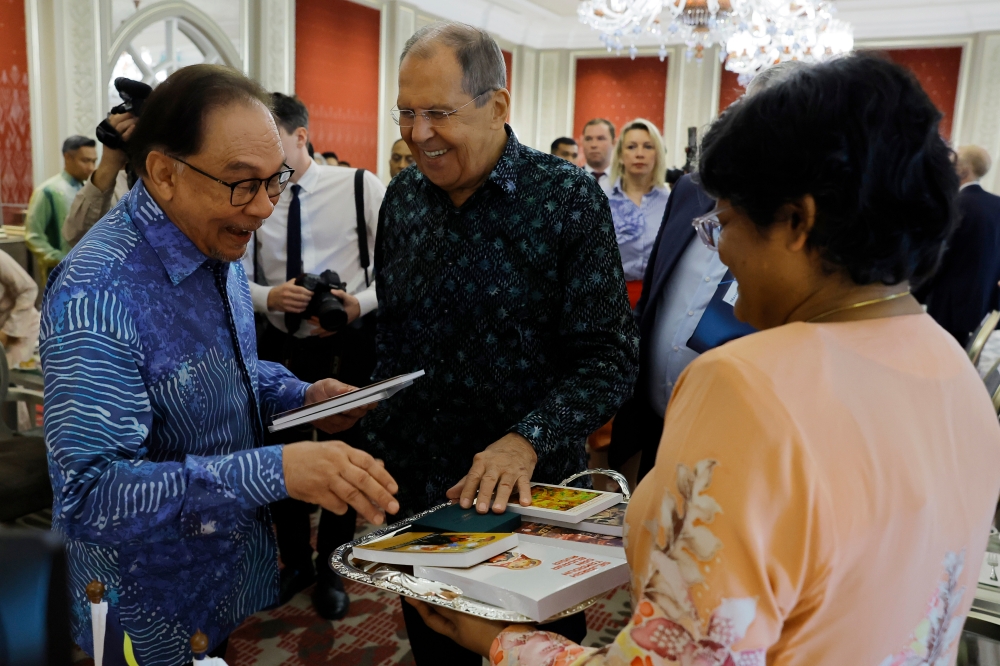 Prime Minister Datuk Seri Anwar Ibrahim (left) receives a book from Russian Foreign Minister Sergey Lavrov (centre) in conjunction with his courtesy visit to Malaysia at Seri Perdana July 28, 2024. — Bernama pic