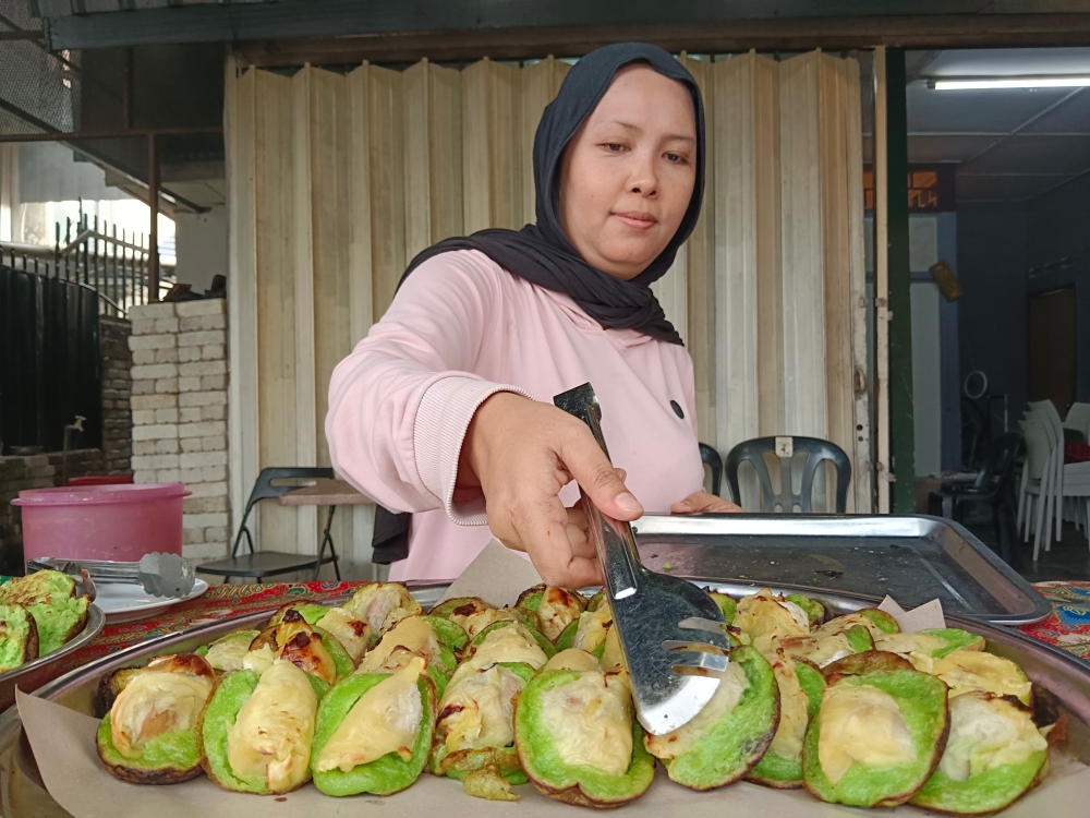 Saniah Mohammed Salim arranges akok at her stall in Kampung Baru. — Bernama pic