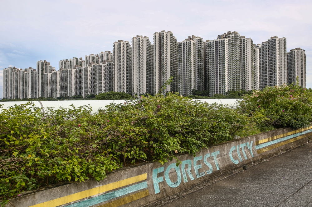 Condominiums are seen in the background of a road leading to Forest City in Gelang Patah, Johor Baru. — Picture by Yusof Mat Isa