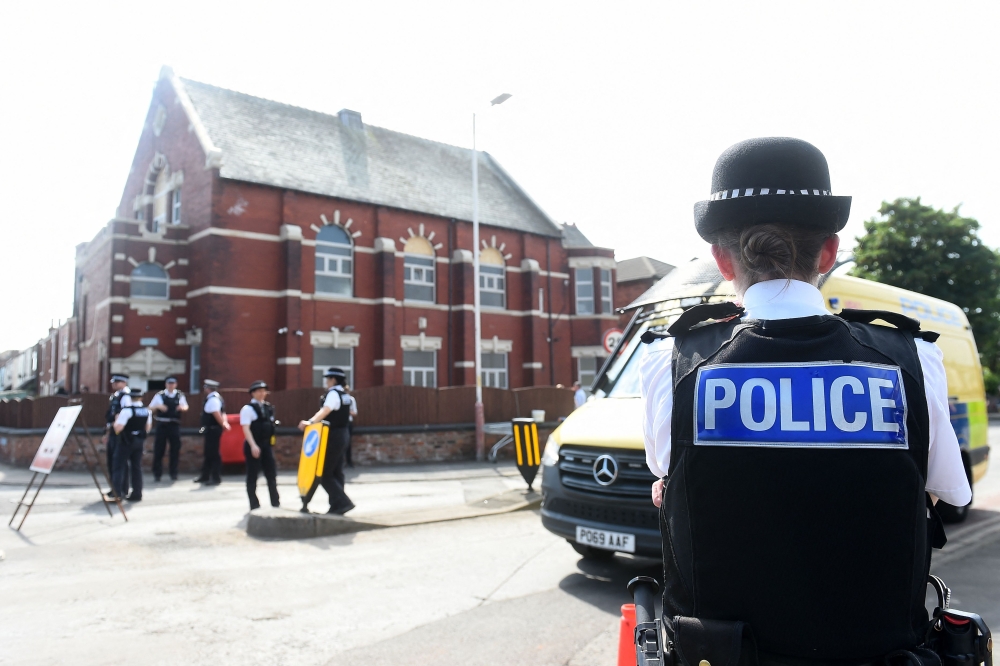 Police officers stand guard outside the Southport Islamic Society Mosque in Southport, northwest England, July 31, 2024. — AFP pic