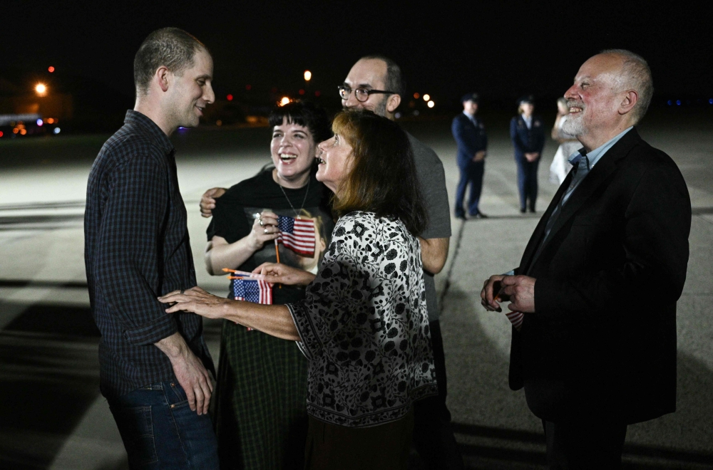 Former prisoner held by Russia US journalist Evan Gershkovich is greeted by his parents Mikhail Gershkovich and Ella Milman with his sister Danielle Gershkovich and brother-in-law Anthony Huczek as he arrives at Joint Base Andrews in Maryland on August 1, 2024. — AFP pic