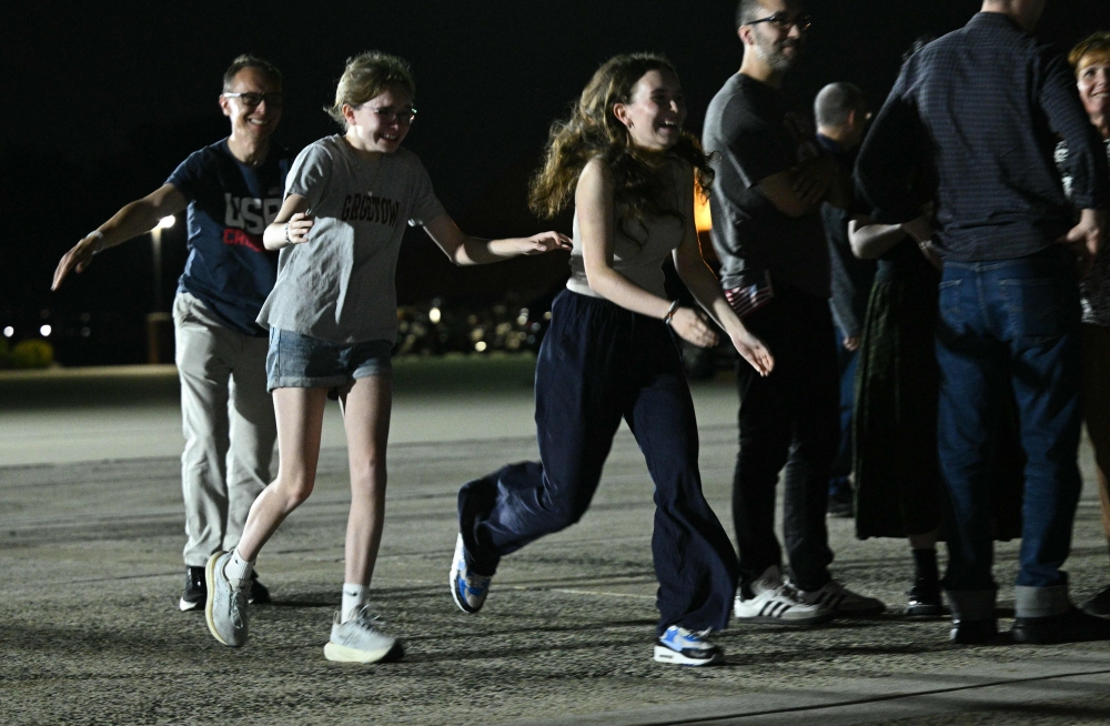 US-Russian journalist Alsu Kurmasheva’s husband Pavel Butorin and their daughters Miriam Butorin and Bibi Butorinas run to greet her as she arrives at Joint Base Andrews in Maryland on August 1, 2024. — AFP pic