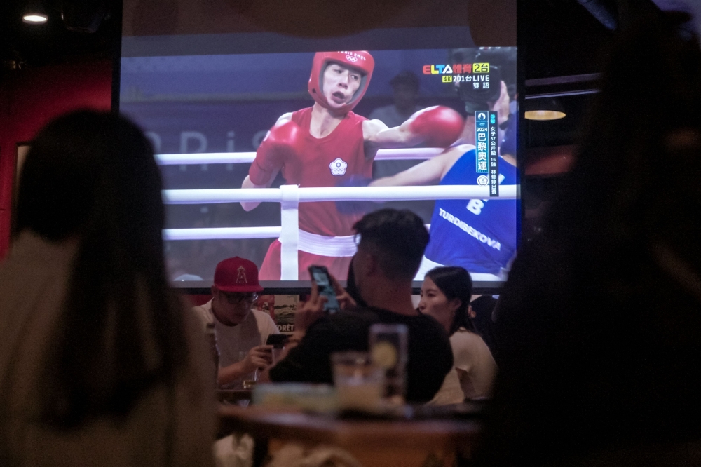 A screen shows Taiwan’s Lin Yu-ting (centre) fighting against Uzbekistan’s Sitora Turdibekova in the women’s 57kg preliminaries round of 16 boxing match during the Paris 2024 Olympic Games, during a live telecast of Olympic Games at a sports bar in Taipei August 2, 2024. — AFP pic