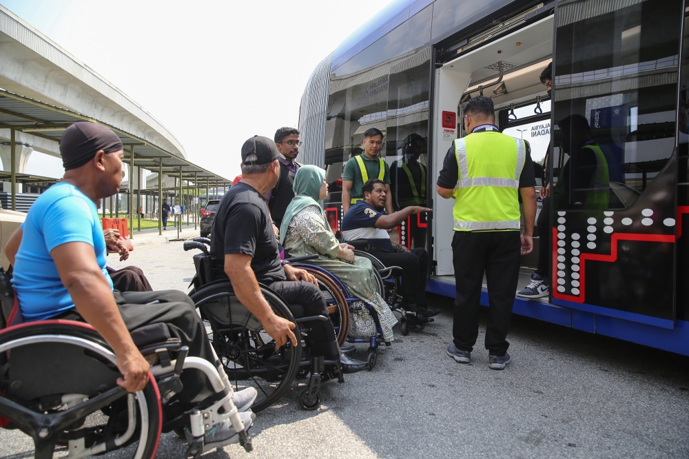 People with disabilities queue to board a trackless tram outside the Putrajaya Sentral Station in Putrajaya, on July 21, 2024. — Picture by Yusof Mat Isa