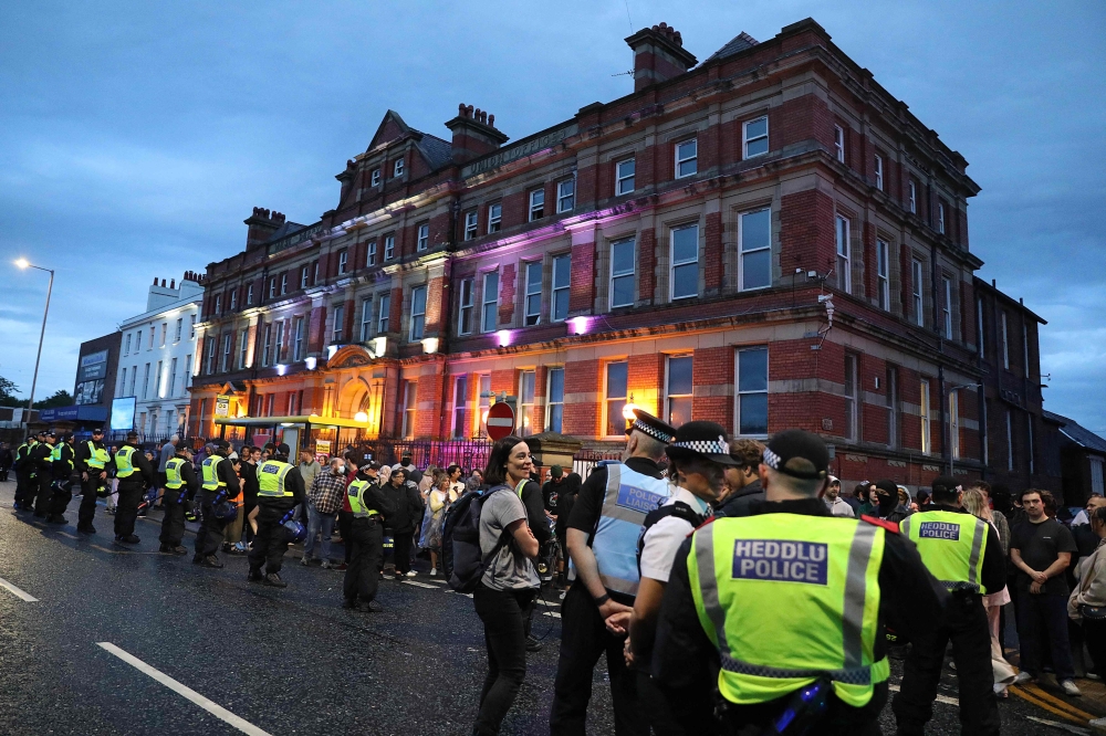 Police officers stand guard between protesters defending the Abdullah Quilliam Mosque in Liverpool on August 2, 2024 against the ‘Enough is Enough’ demonstration called in reaction to the fatal stabbings in Southport on July 29. — AFP pic