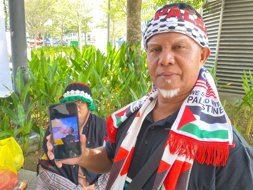 Muzahar Hitam, 61, showing a photograph of him meeting Ismail Haniyeh in Gaza during a humanitarian mission in 2012. — Picture by Dhesegaan Bala Krishnan