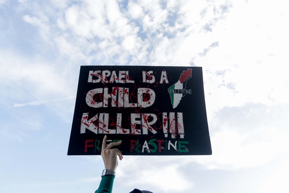 An attendee holds up a sign before the Palestine Liberation Rally held at Axiata Arena in Kuala Lumpur on Aug 4, 2024. — Picture by Sayuti Zainudin