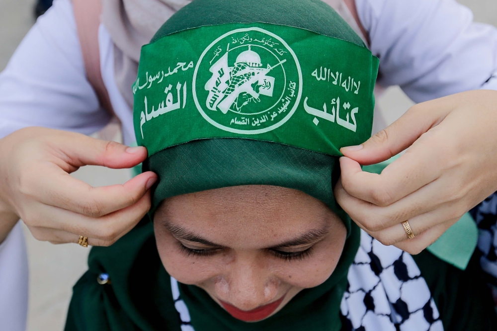 An attendee dons a headband before the Palestine Liberation Rally held at Axiata Arena in Kuala Lumpur on Aug 4, 2024. — Picture by Sayuti Zainudin