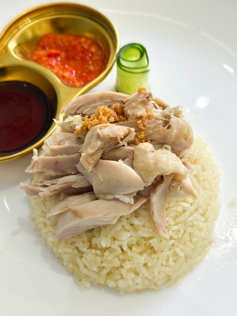 A close-up of the chicken rice, with its deboned chicken thigh crowning an upturned bowl of rice that is fragrant and fluffy grains. — Picture by Lee Khang Yi