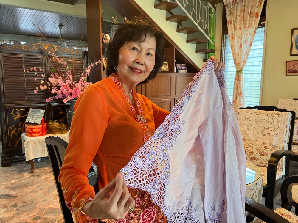 Susan Tan shows off a Nyonya kebaya that her mother made.  — Picture by Opalyn Mok