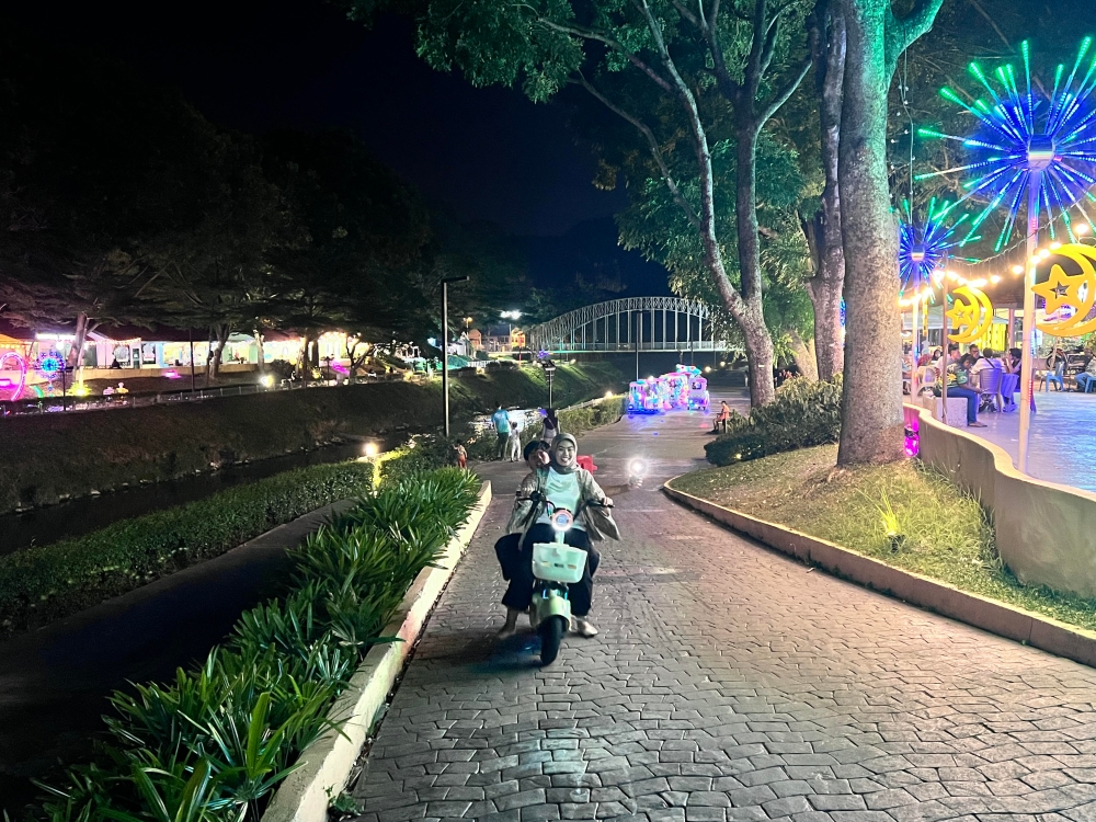 Locals and visitors enjoying the lights and charm of Kinta Riverfront in Ipoh. — Picture by John Bunyan