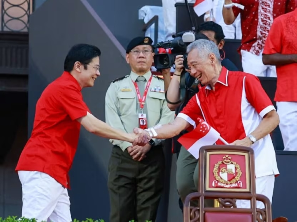 Singapore Prime Minister Lawrence Wong shaking hands with Senior Minister Lee Hsien Loong at the National Day Parade 2024 at the Padang in Singapore August 9, 2024. — TODAY pic