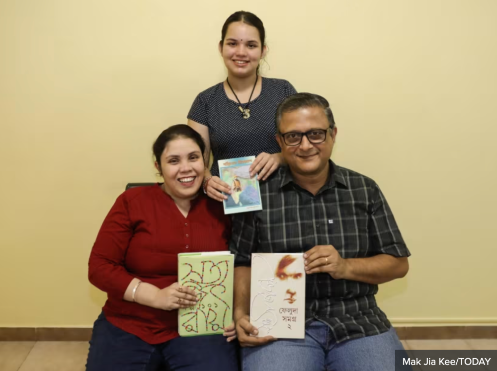 (Seated, from left) Ms Archita Biswas and Mr Vedha Giri with their daughter Shreya in their home. For 14-year-old Shreya, having Bengali as her mother tongue language means waking up early on Saturdays for lessons, since her school offers only Tamil.Secondary school Malay language teacher Nur Asyikin Naser reading storybooks in Malay with her children. — TODAY pic