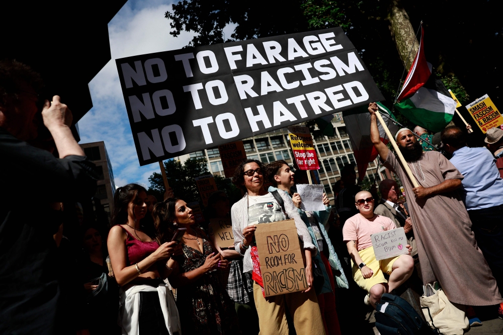 People hold anti-racism placards as they take part in a 