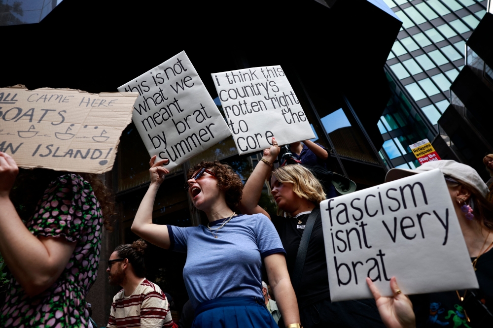 People hold anti-racism placards as they take part in a 