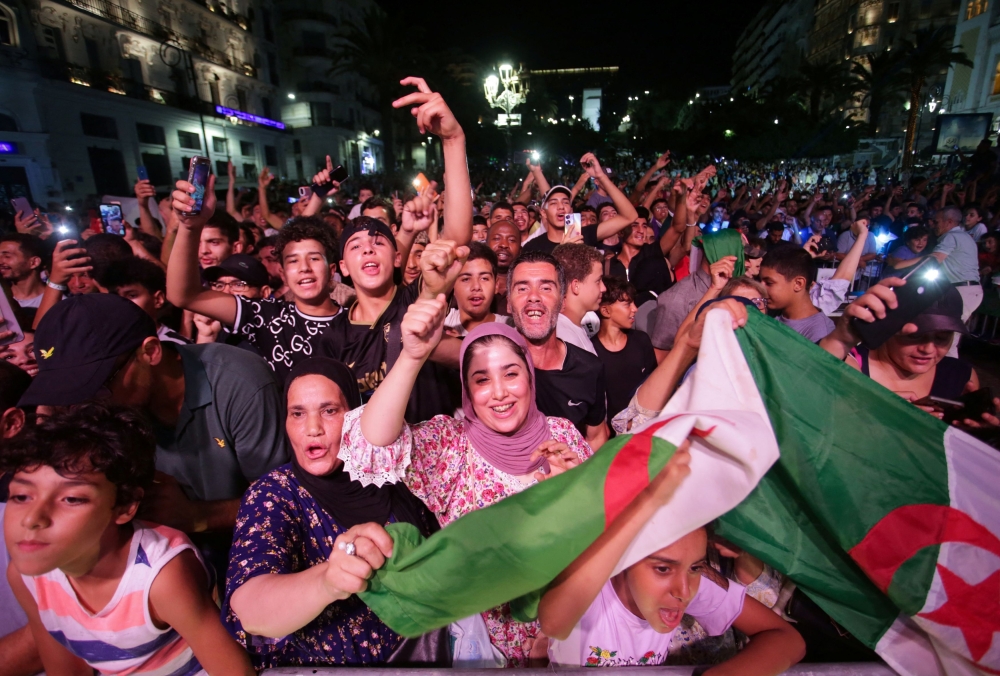 People celebrate after Algerian boxer, Imane Khelif, beat China's Yang Liu to claim the gold medal in the women's welterweight boxing at the Olympics, in Algiers, Algeria. — Reuters pic