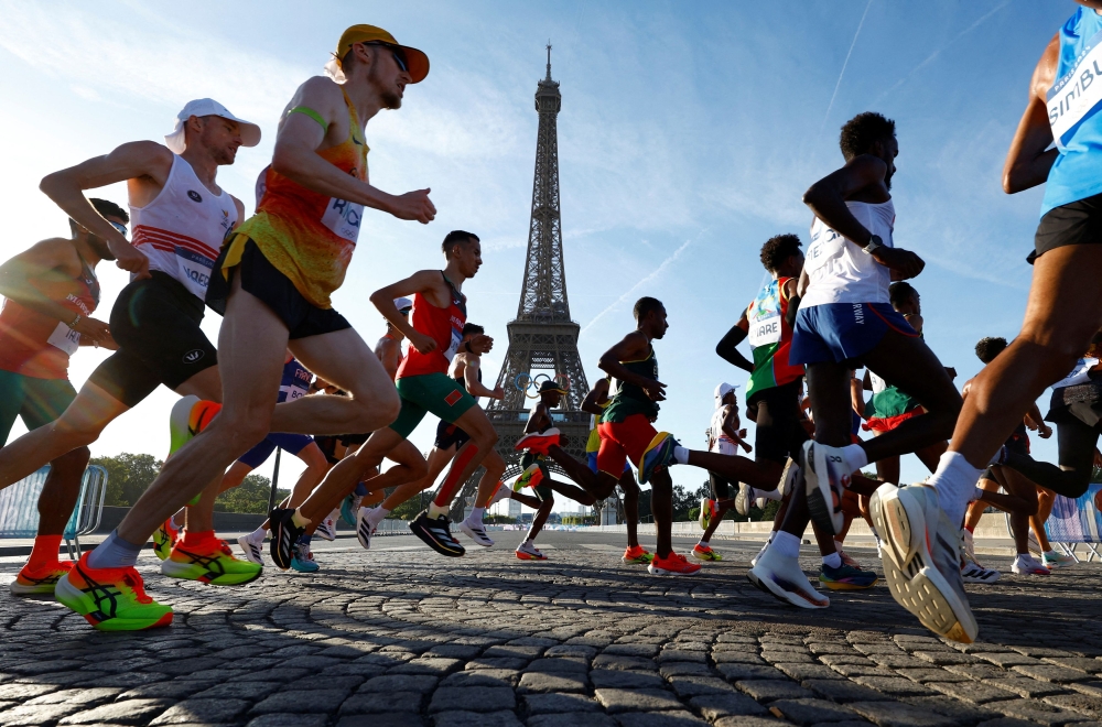 Athletes run past the Eiffel Tower during the race. — Reuters pic