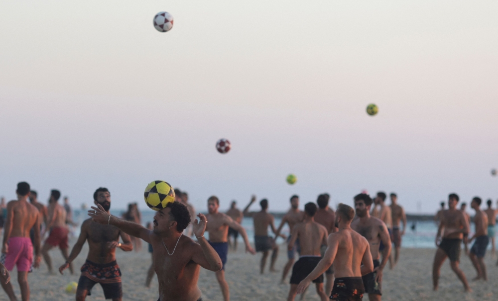 Beachgoers play with soccer balls at the beach, amid the ongoing conflict between Hamas and Israel, in Tel Aviv, Israel, August 4, 2024. — Reuters pic