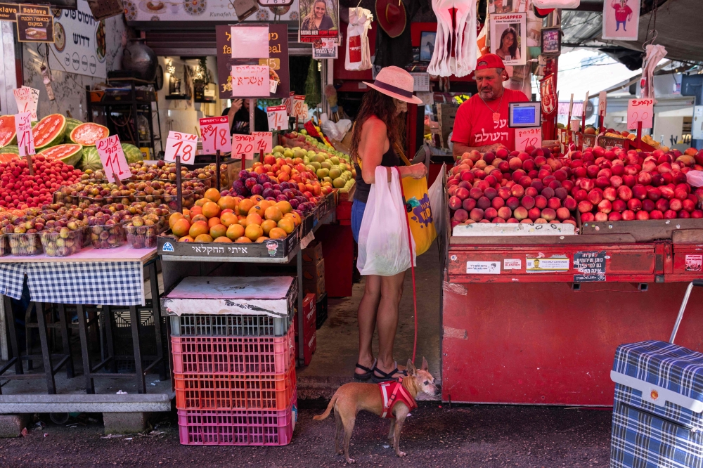 An Israeli woman shops with her dog at the Carmel market in Tel Aviv, on August 7, 2024, amid regional tensions during the ongoing war between Israel and the Palestinian Hamas movement in the Gaza Strip. — AFP pic